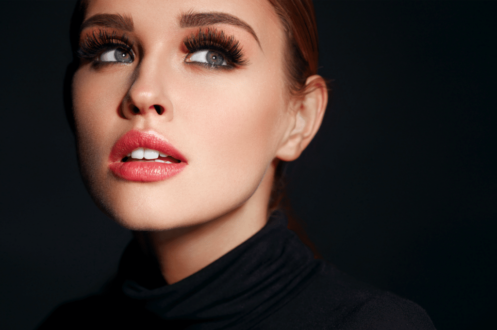 A beautiful woman with long lash extensions on a black background